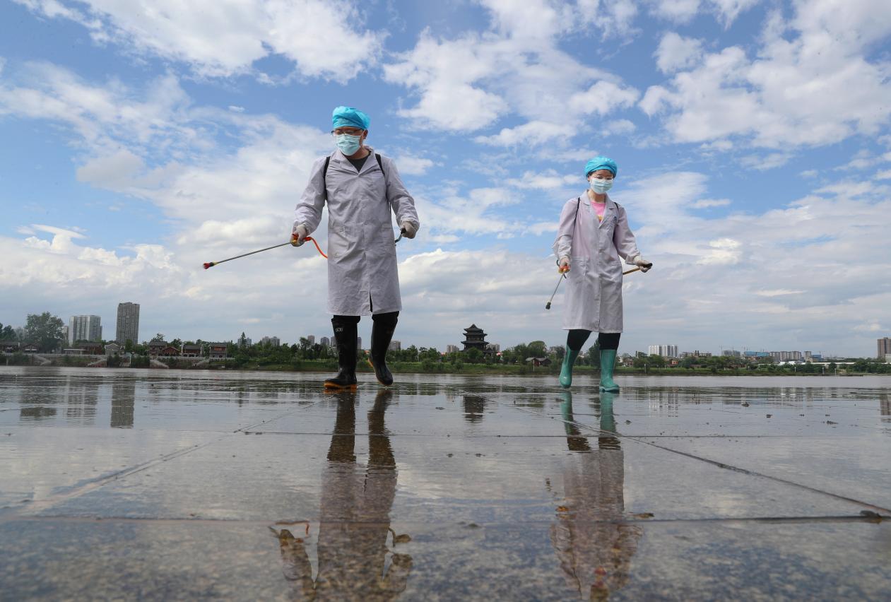 2021年5月26日。在湖南省衡阳市雁峰区千吨级码头沿江风光带，英国365集团官网公共卫生学院的党员志愿者在给清除淤泥后的地方举行消毒。  (2)